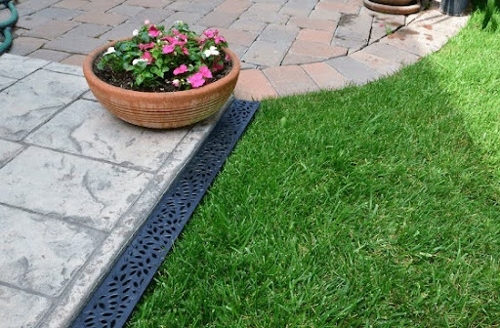 a pot of flowers on the corner of a patio