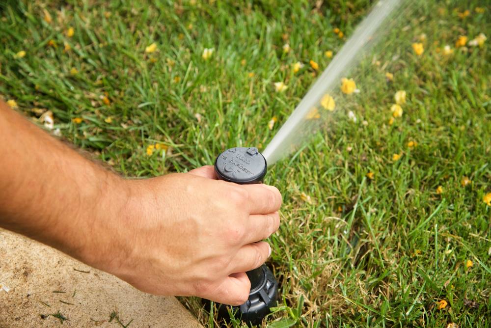 man fixing sprinkler head