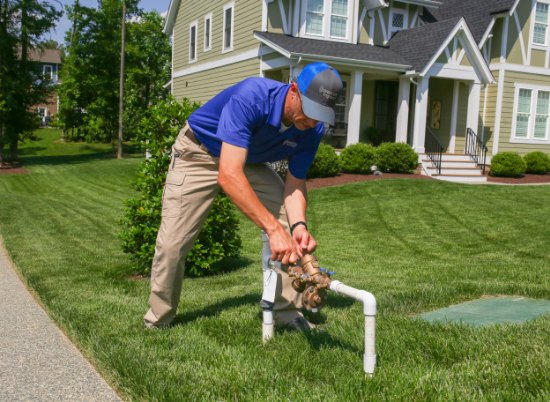 Technician installing or repairing a backflow system