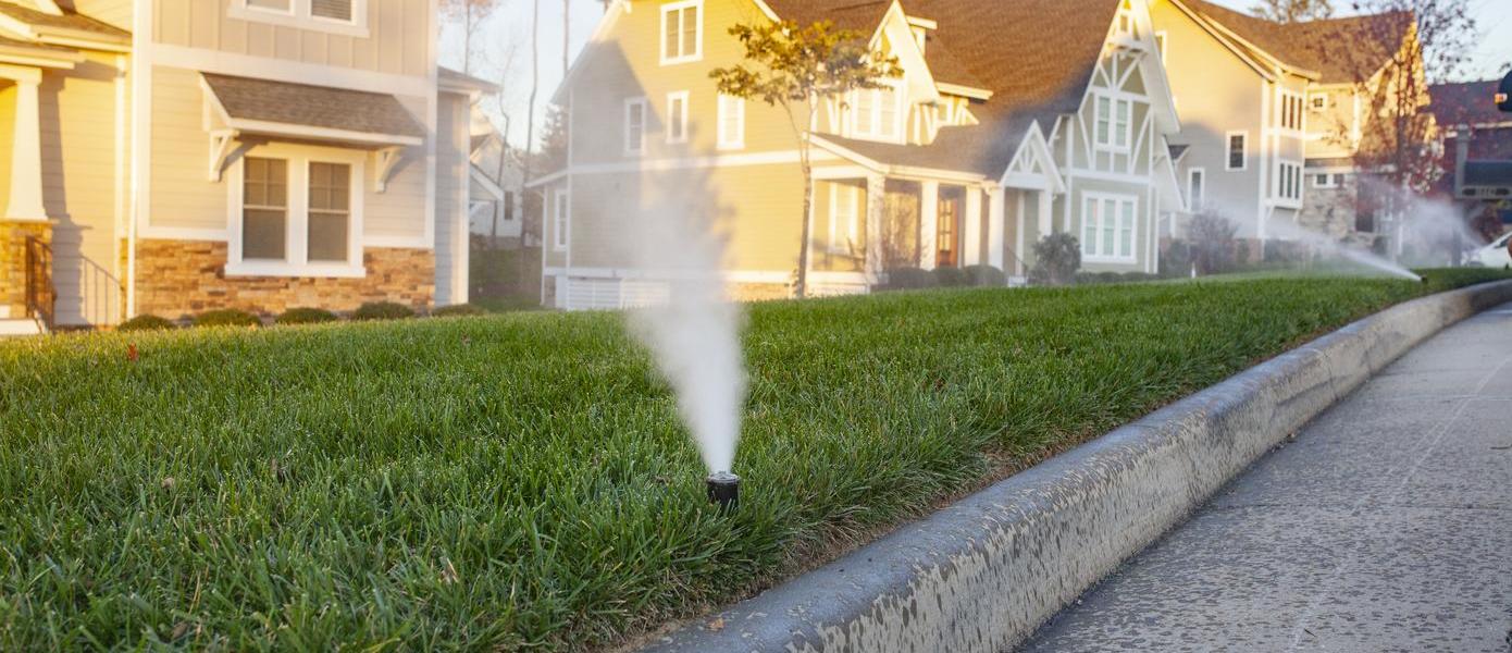 Sprinkler system running in front yards in neighborhood