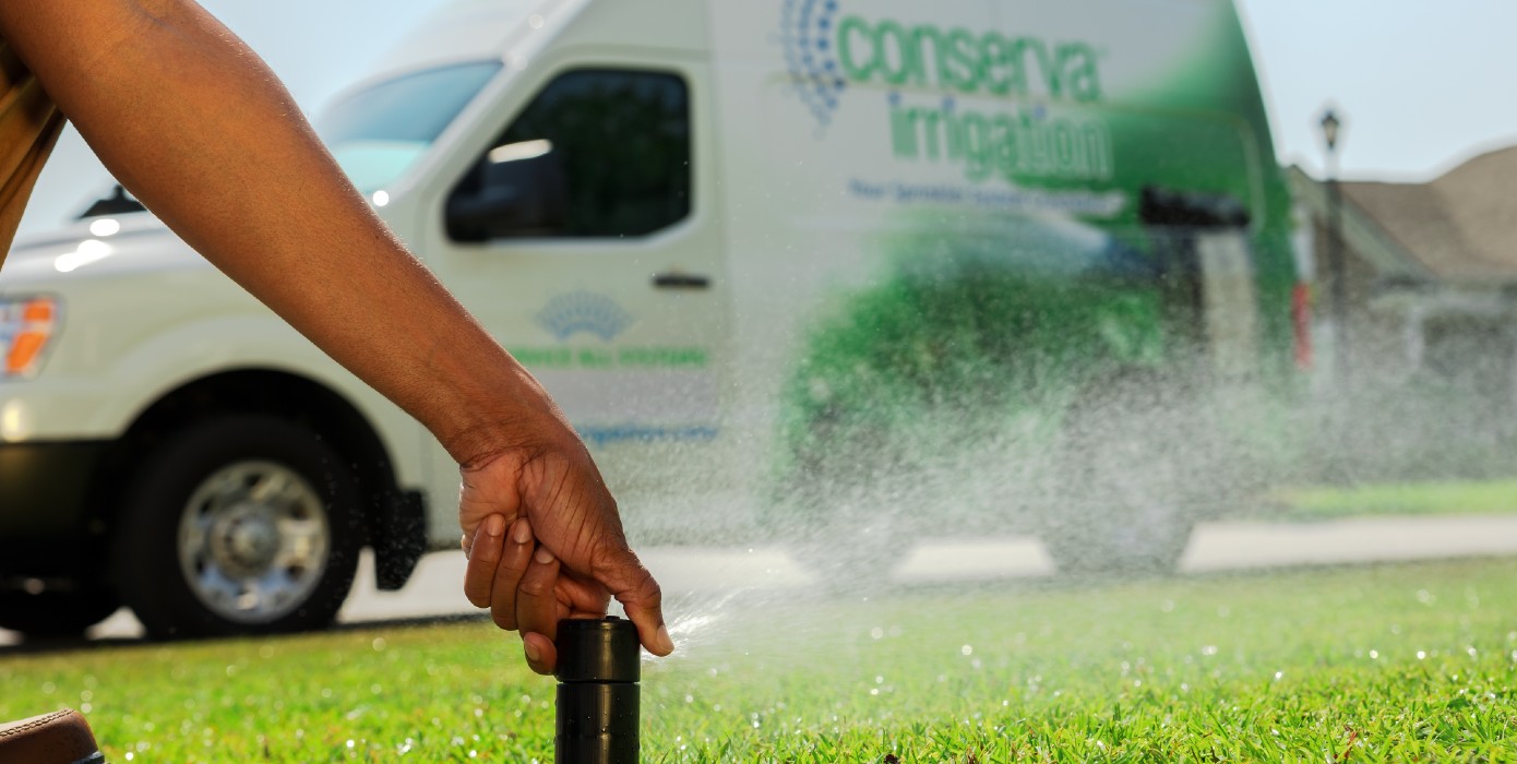 Conserva Irrigation employee grabing a sprinkler
