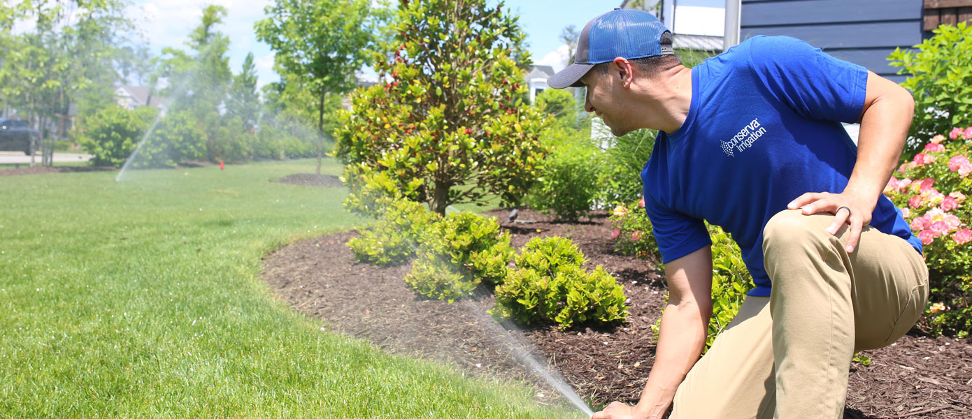 technician adjusting sprinkler 